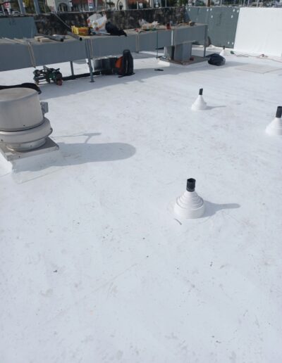 A rooftop with various vents, equipment, and some scattered debris under a bright sky.